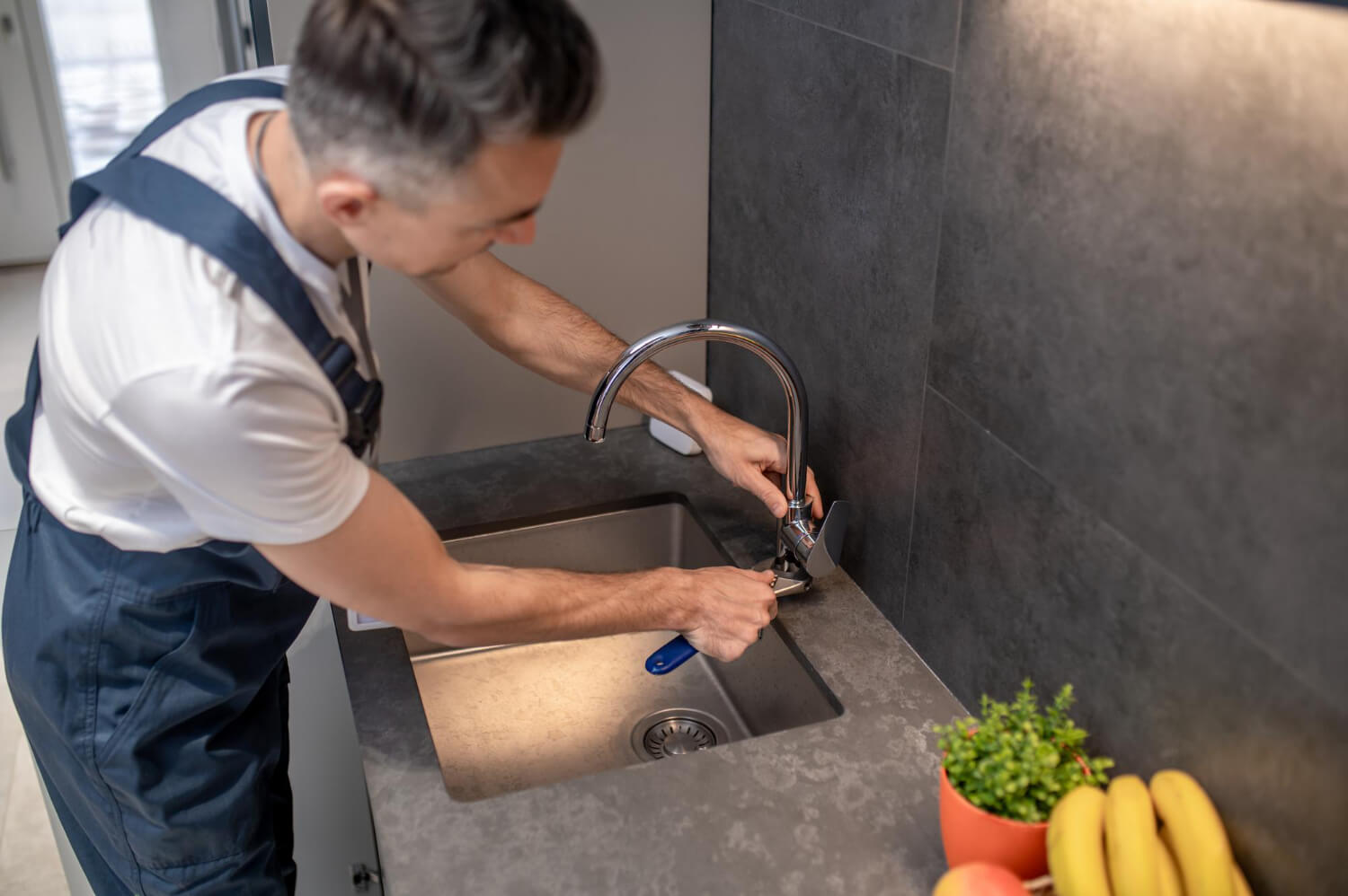 Expert Plumbing Services in Stuart, Florida – Everest Mechanical Professional plumber repairing a kitchen sink in a residential home in Stuart, Florida.